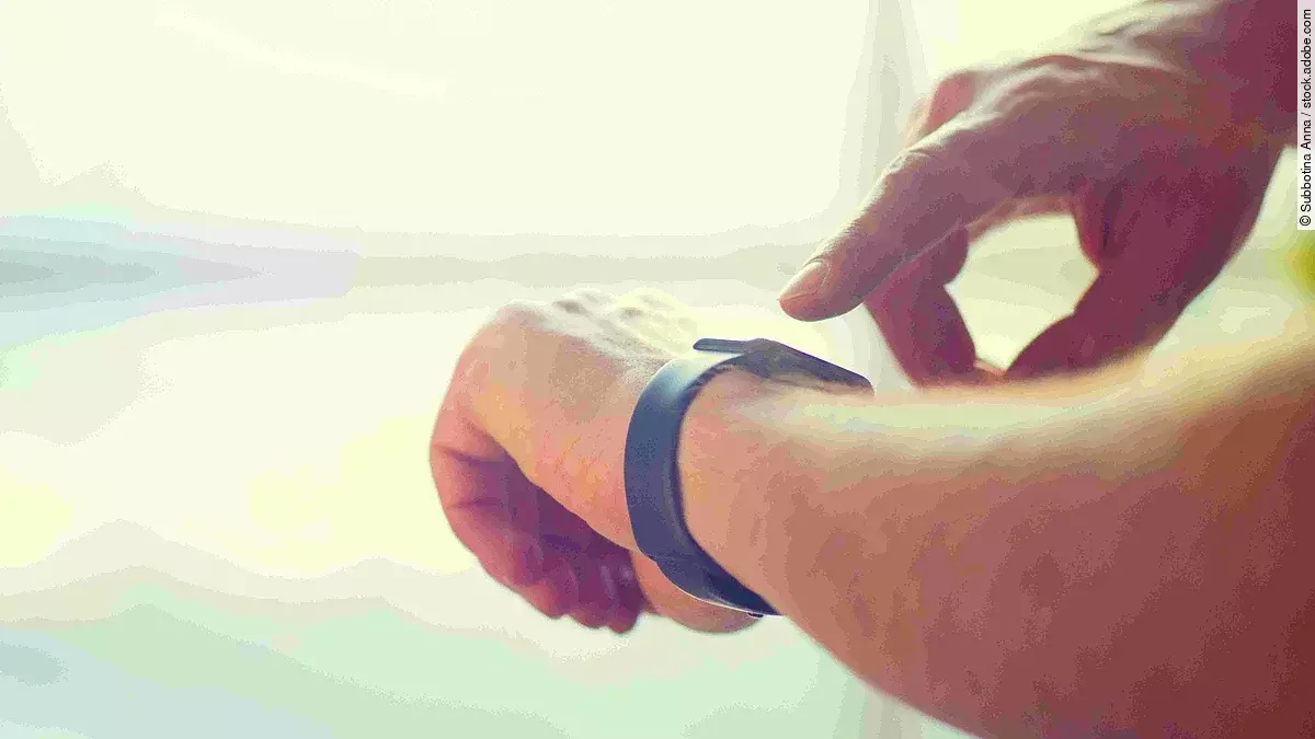 Zeiterfassung Eine Person tippt auf seine Smartwatch, die er am Handgelenk trägt.