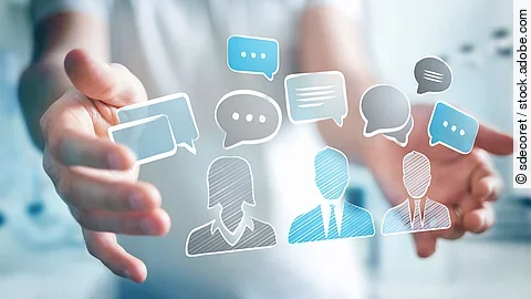 Person mit ausgestreckten Händen. Dazwischen eine holografische Anordnung von Chat-Symbolen.