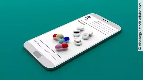 Auf einem animierten Smartphone liegen verschiedene Medikamente und Tabletten.