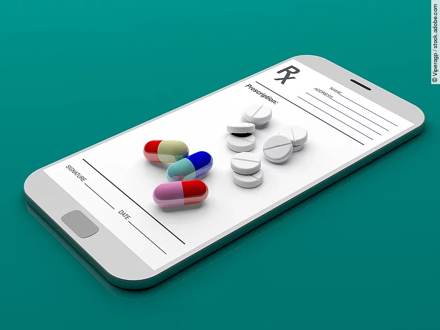 E-Rezept Auf einem animierten Smartphone liegen verschiedene Medikamente und Tabletten.