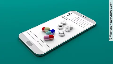 Auf einem animierten Smartphone liegen verschiedene Medikamente und Tabletten.