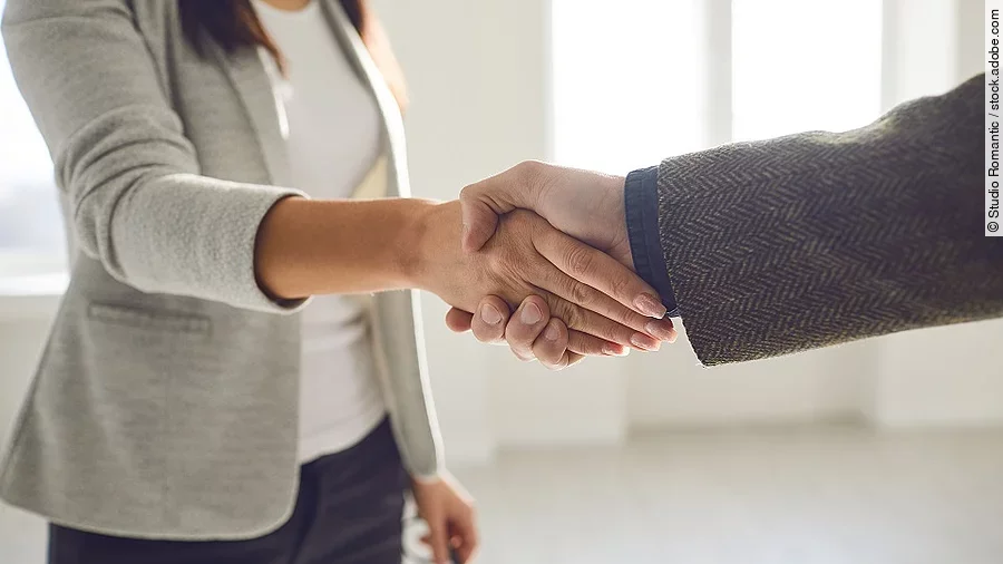 Handschlag einer Frau und eines Mannes im Anzug