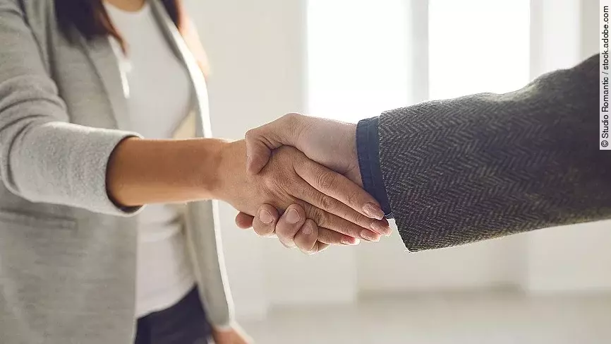 Handschlag einer Frau und eines Mannes im Anzug
