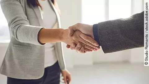 Handschlag einer Frau und eines Mannes im Anzug