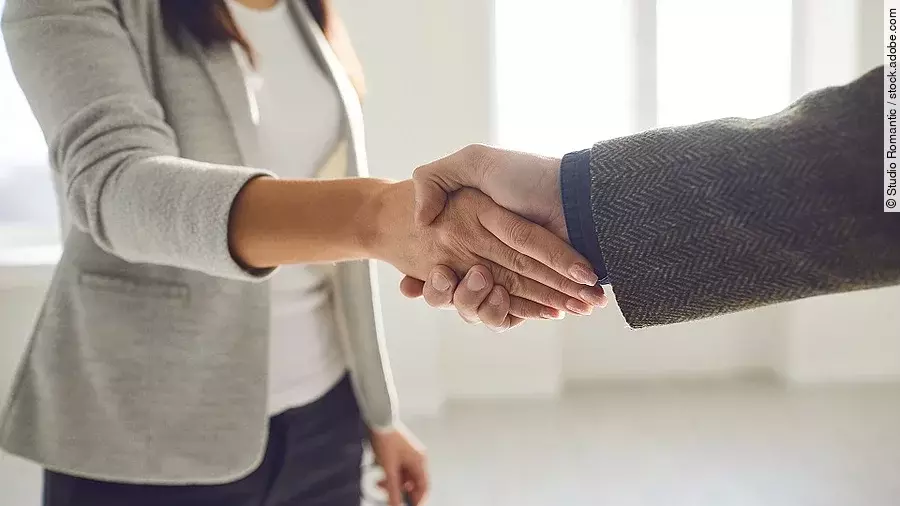 Handschlag einer Frau und eines Mannes im Anzug