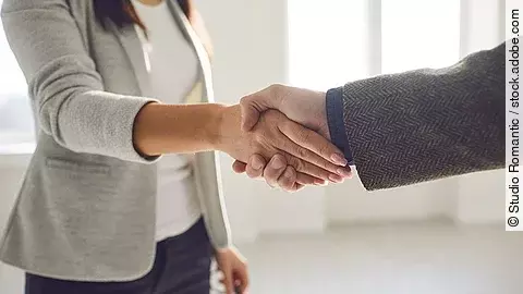 Handschlag einer Frau und eines Mannes im Anzug