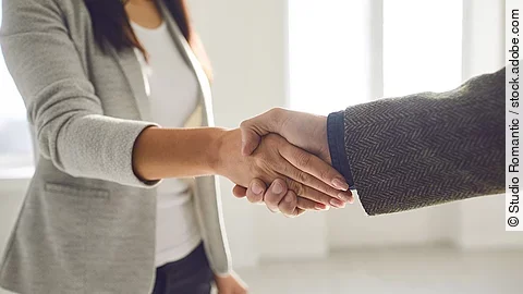 Handschlag einer Frau und eines Mannes im Anzug