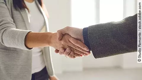 Handschlag einer Frau und eines Mannes im Anzug