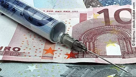 Spritze liegt auf Geldscheinen 