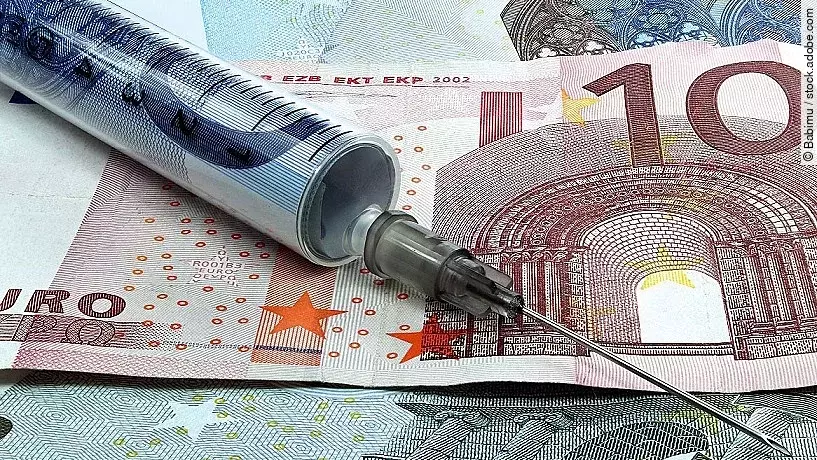 Finanzspritze Spritze liegt auf Geldscheinen