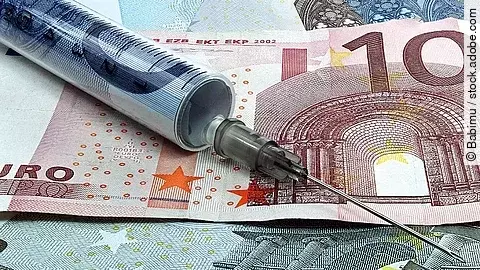 Spritze liegt auf Geldscheinen 