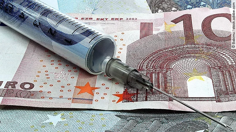 Finanzspritze Spritze liegt auf Geldscheinen