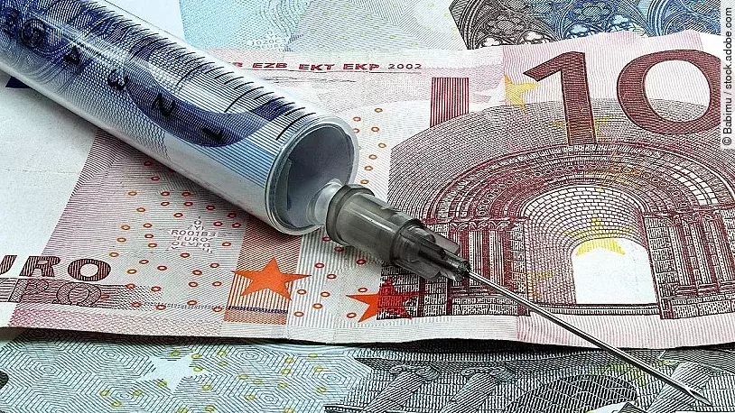 Finanzspritze Spritze liegt auf Geldscheinen