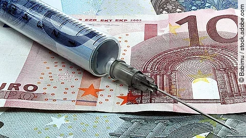 Spritze liegt auf Geldscheinen 