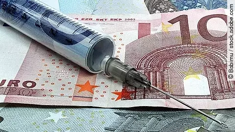 Spritze liegt auf Geldscheinen 