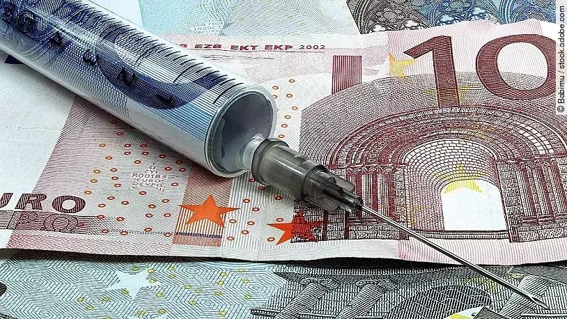 Spritze liegt auf Geldscheinen 