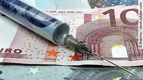 Spritze liegt auf Geldscheinen 