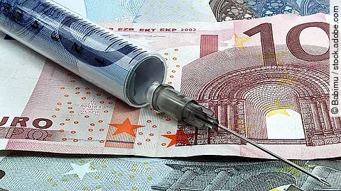 Finanzspritze Spritze liegt auf Geldscheinen