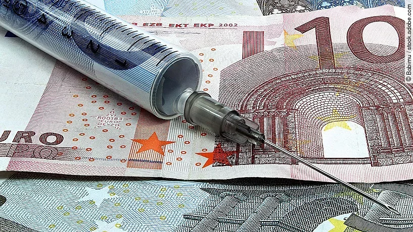 Spritze liegt auf Geldscheinen 