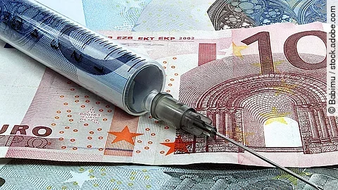 Spritze liegt auf Geldscheinen 