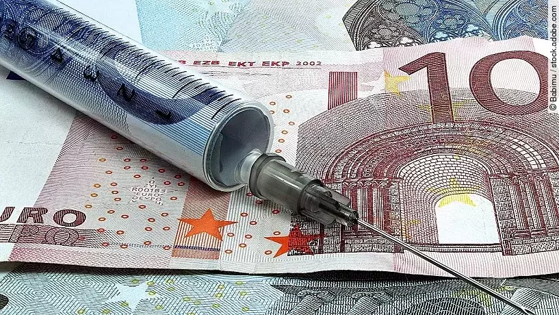 Spritze liegt auf Geldscheinen 