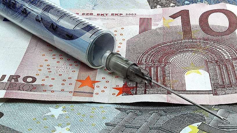 Finanzspritze Spritze liegt auf Geldscheinen