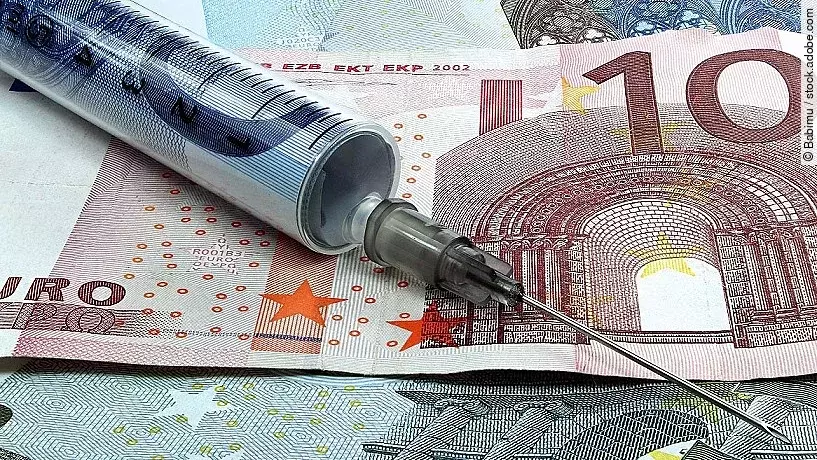 Spritze liegt auf Geldscheinen 