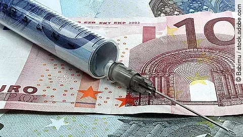 Spritze liegt auf Geldscheinen 