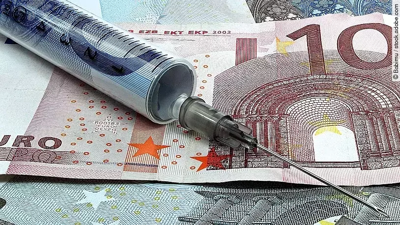 Spritze liegt auf Geldscheinen 