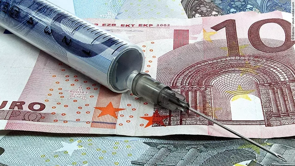 Finanzspritze Spritze liegt auf Geldscheinen