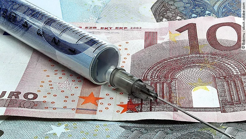 Spritze liegt auf Geldscheinen 