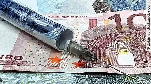 Spritze liegt auf Geldscheinen 