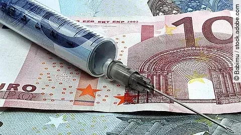 Spritze liegt auf Geldscheinen 