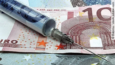 Spritze liegt auf Geldscheinen 