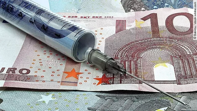 Spritze liegt auf Geldscheinen 