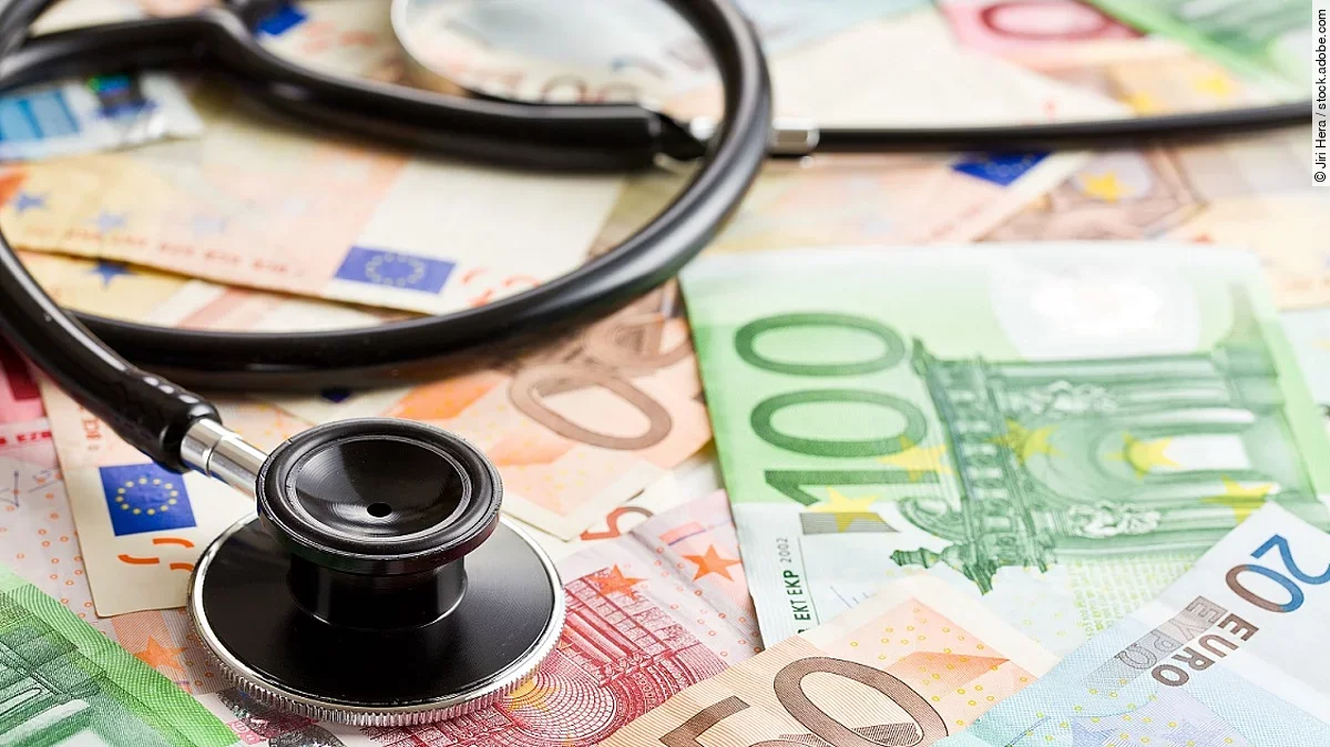 Mehrere Banknoten liegen verteilt und auf ihnen ein Stethoskop.