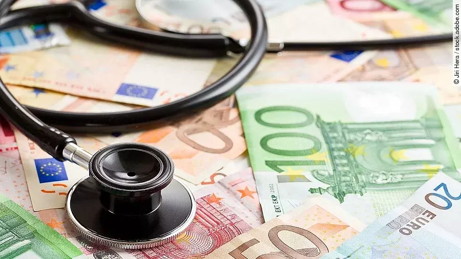 Mehrere Banknoten liegen verteilt und auf ihnen ein Stethoskop.