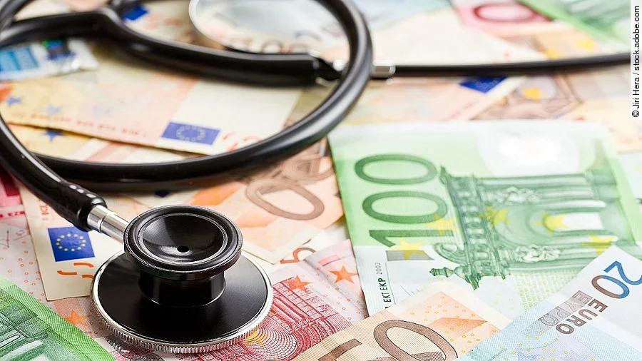 Rettungsschirm für Kliniken Mehrere Banknoten liegen verteilt und auf ihnen ein Stethoskop.