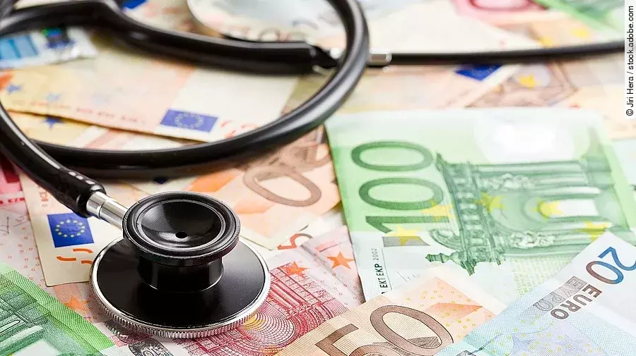 Mehrere Banknoten liegen verteilt und auf ihnen ein Stethoskop.