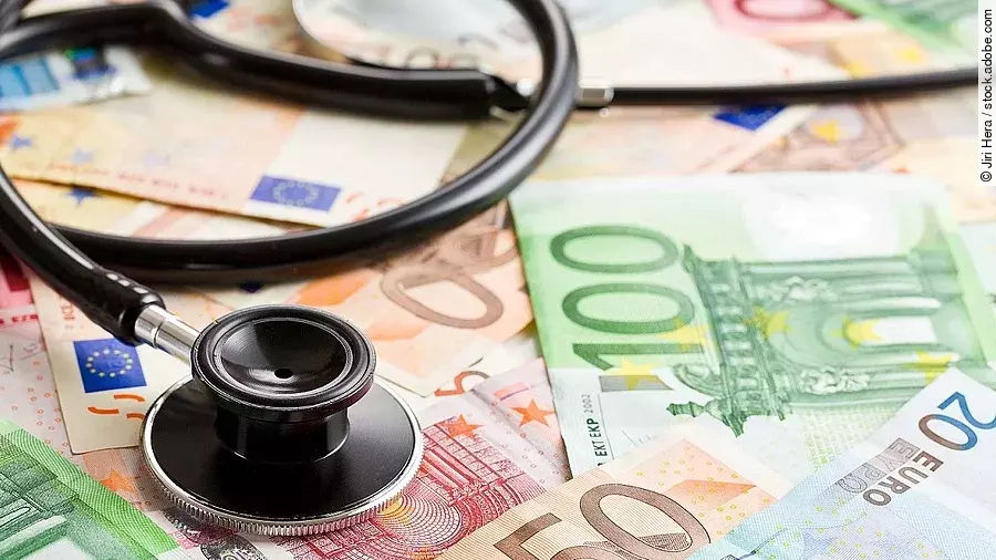 Mehrere Banknoten liegen verteilt und auf ihnen ein Stethoskop.