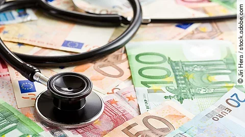 Mehrere Banknoten liegen verteilt und auf ihnen ein Stethoskop.