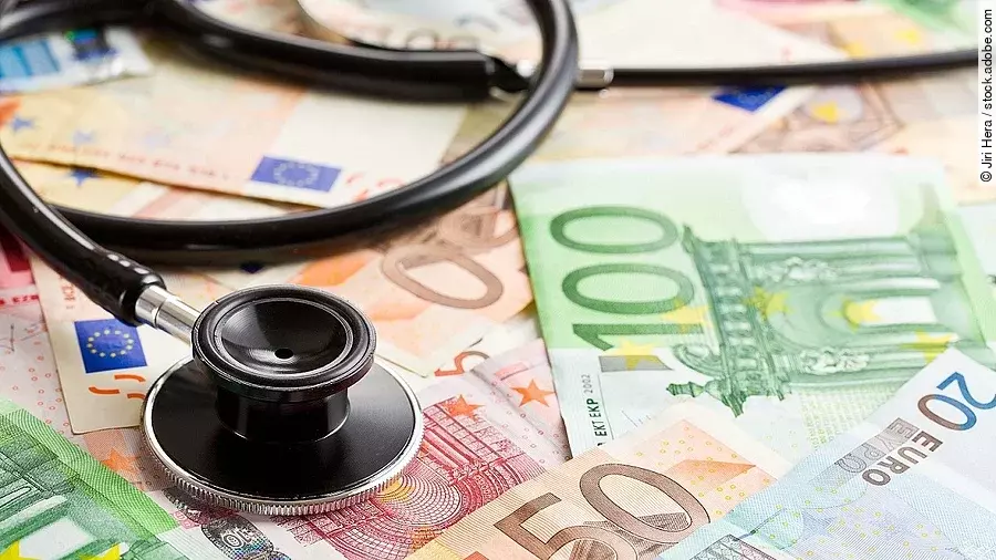 Mehrere Banknoten liegen verteilt und auf ihnen ein Stethoskop.