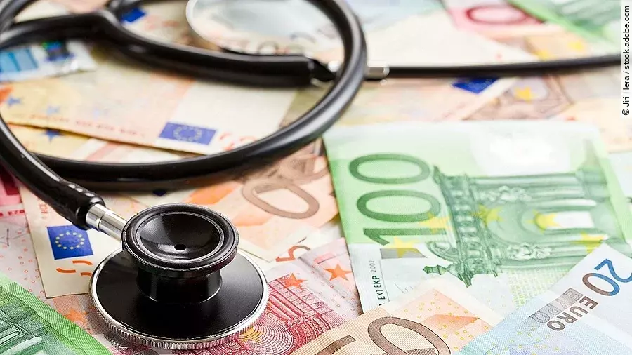Mehrere Banknoten liegen verteilt und auf ihnen ein Stethoskop.