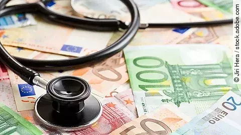 Mehrere Banknoten liegen verteilt und auf ihnen ein Stethoskop.