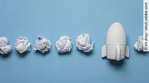 In einer Reihe liegen zusammengeknüllte Blätter Papier. Rechts in der Reihe liegt statt einem Papier eine kleine weiße Rakete.