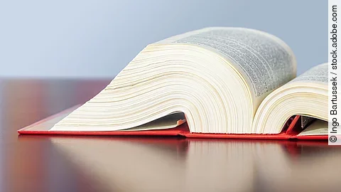 Gesetzbuch liegt aufgeschlagen auf einem Tisch.