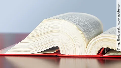 Gesetzbuch liegt aufgeschlagen auf einem Tisch.