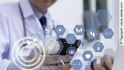 Ein Arzt hält ein Tablet in den Händen. Über dem Gerät schweben Symbole und Icons in einer hologrammartigen Darstellung.