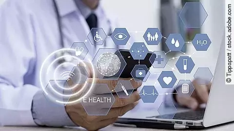 Ein Arzt hält ein Tablet in den Händen. Über dem Gerät schweben Symbole und Icons in einer hologrammartigen Darstellung.