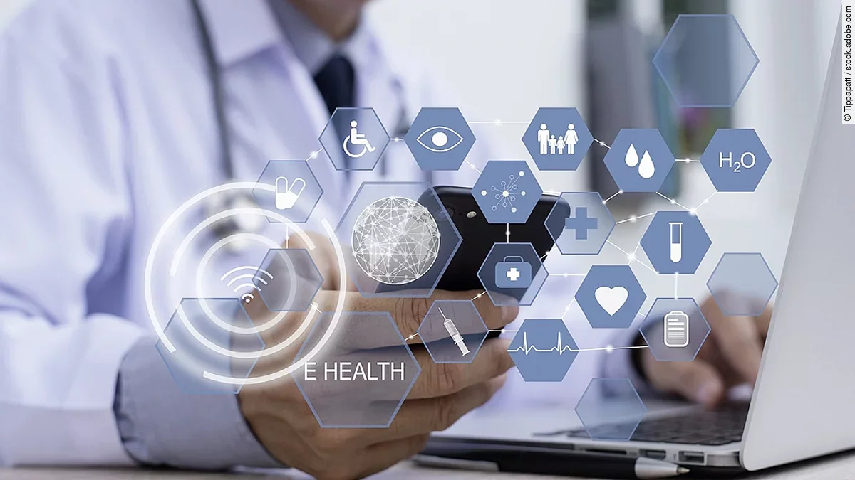 Ein Arzt hält ein Tablet in den Händen. Über dem Gerät schweben Symbole und Icons in einer hologrammartigen Darstellung.